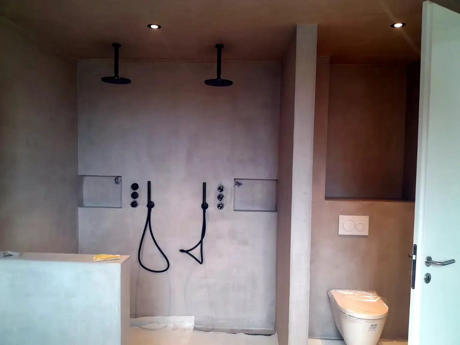 Salle de bains en cours de réalisation avec double équipement de douche.