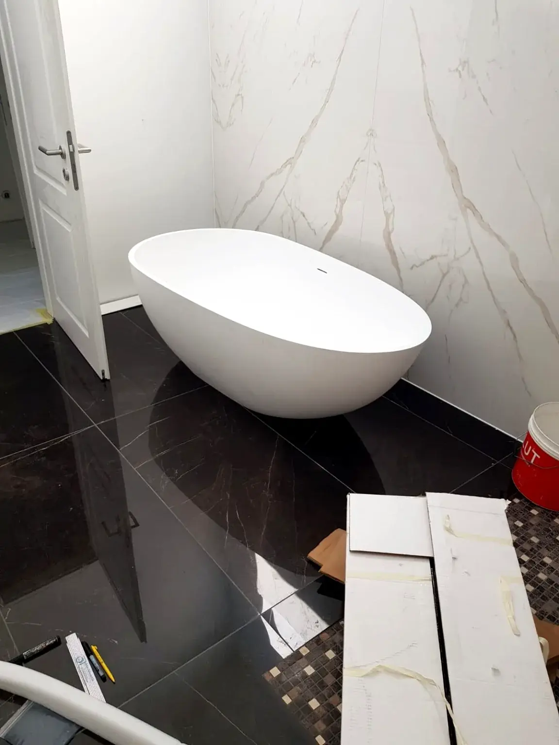 Baignoire îlot sur sol sombre pendant les finitions.