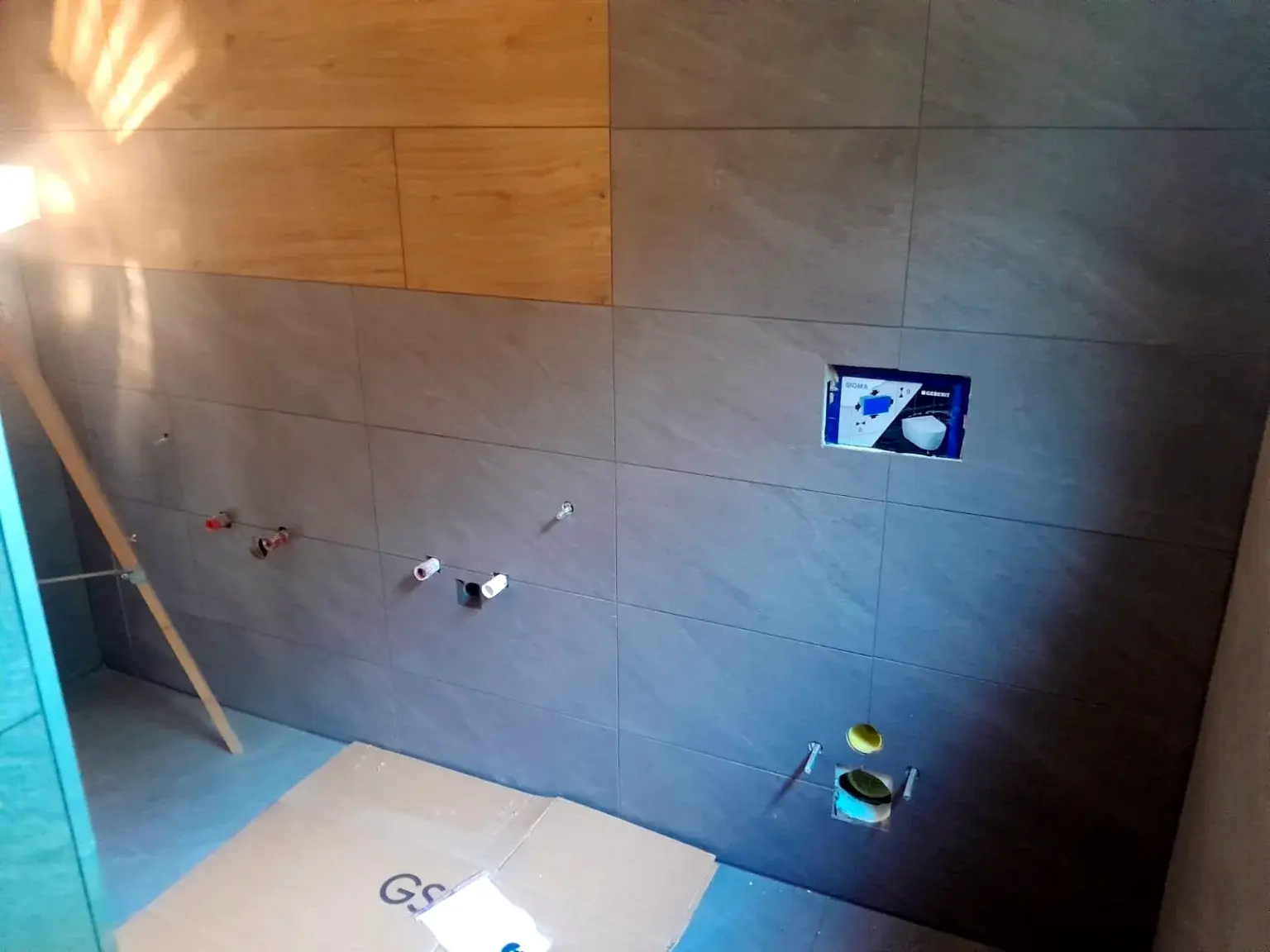 Préparation technique d’un mur de salle de bains avant pose des équipements.