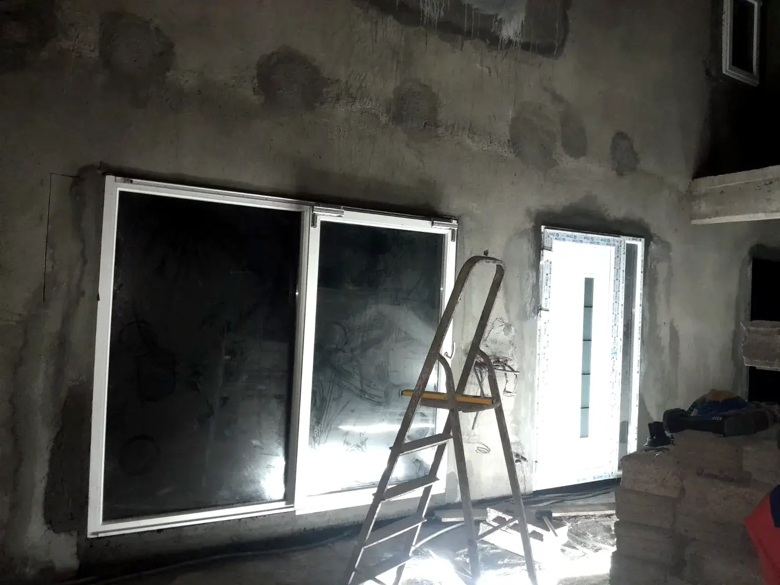 Pose de grandes baies et menuiseries sur une façade en chantier.