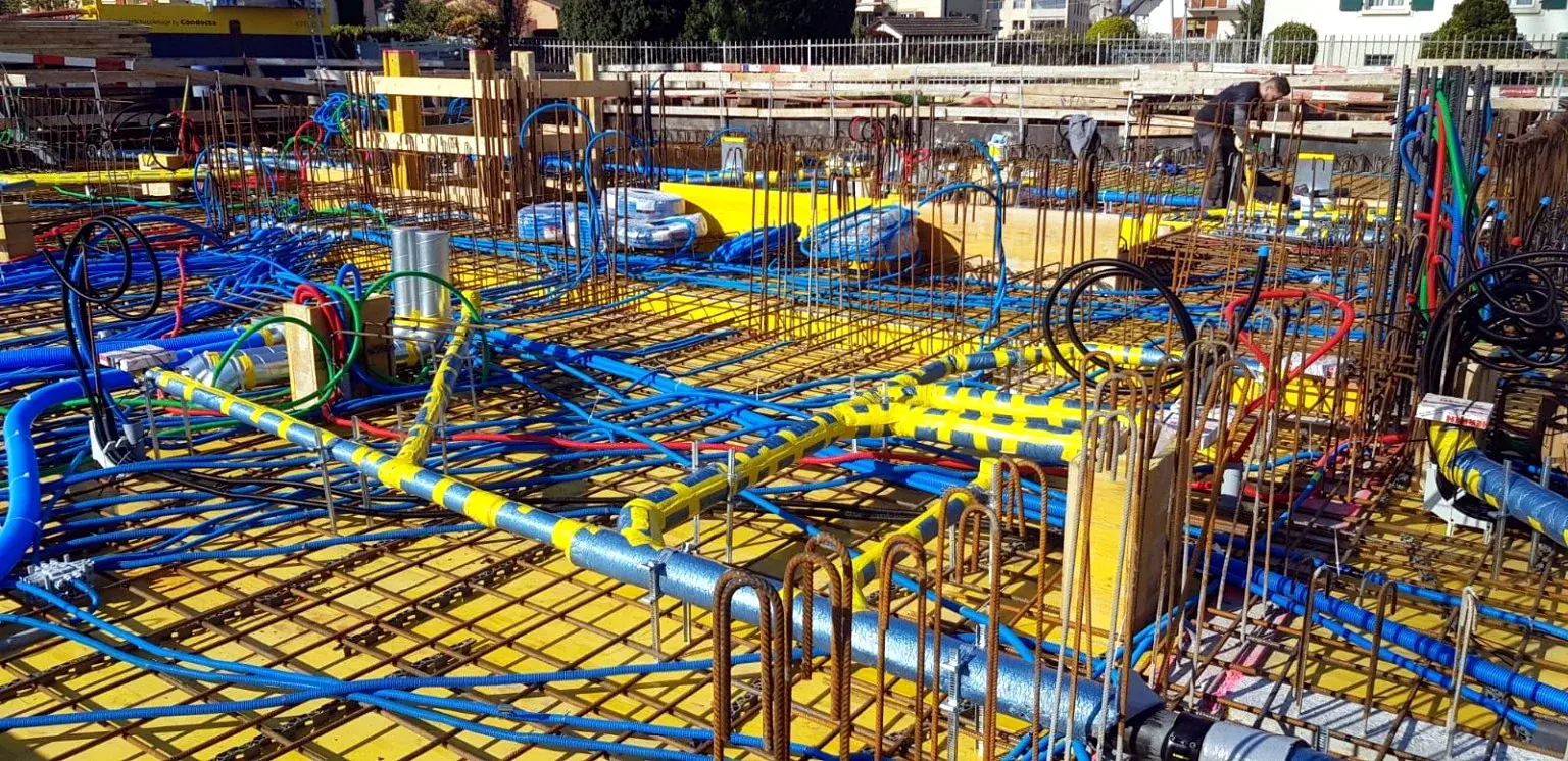 Réseaux techniques codés par couleur installés dans une dalle.