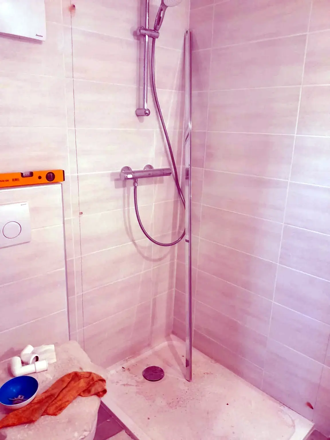 Douche en cours d’installation avec receveur, paroi et colonne de douche.