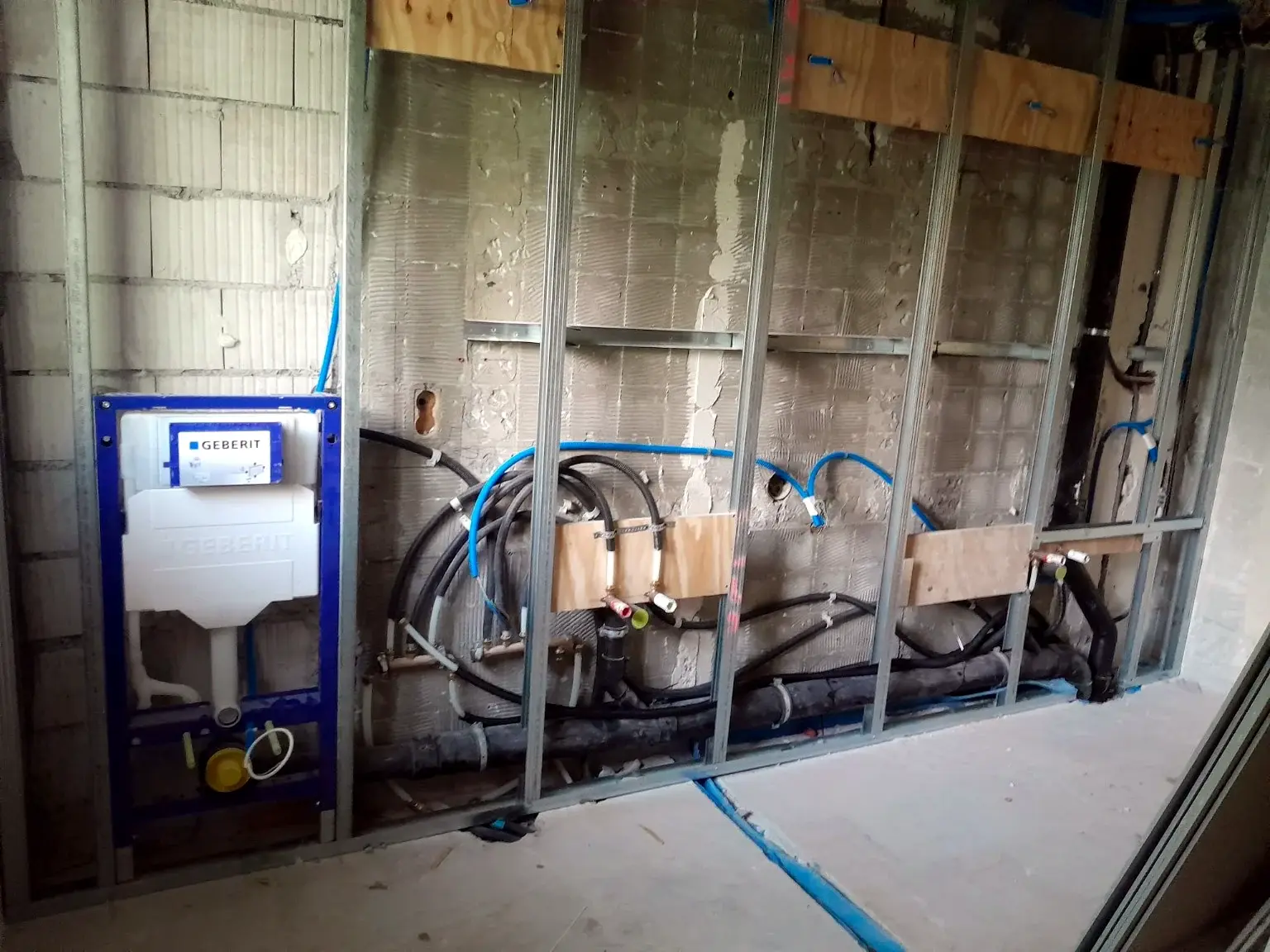 Bâti-support Geberit et réseaux sanitaires intégrés dans une cloison technique.