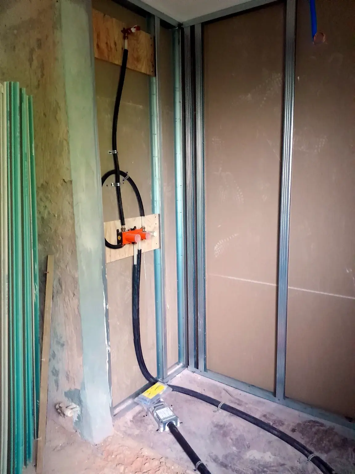 Réseaux de plomberie intégrés dans une cloison métallique avant fermeture.