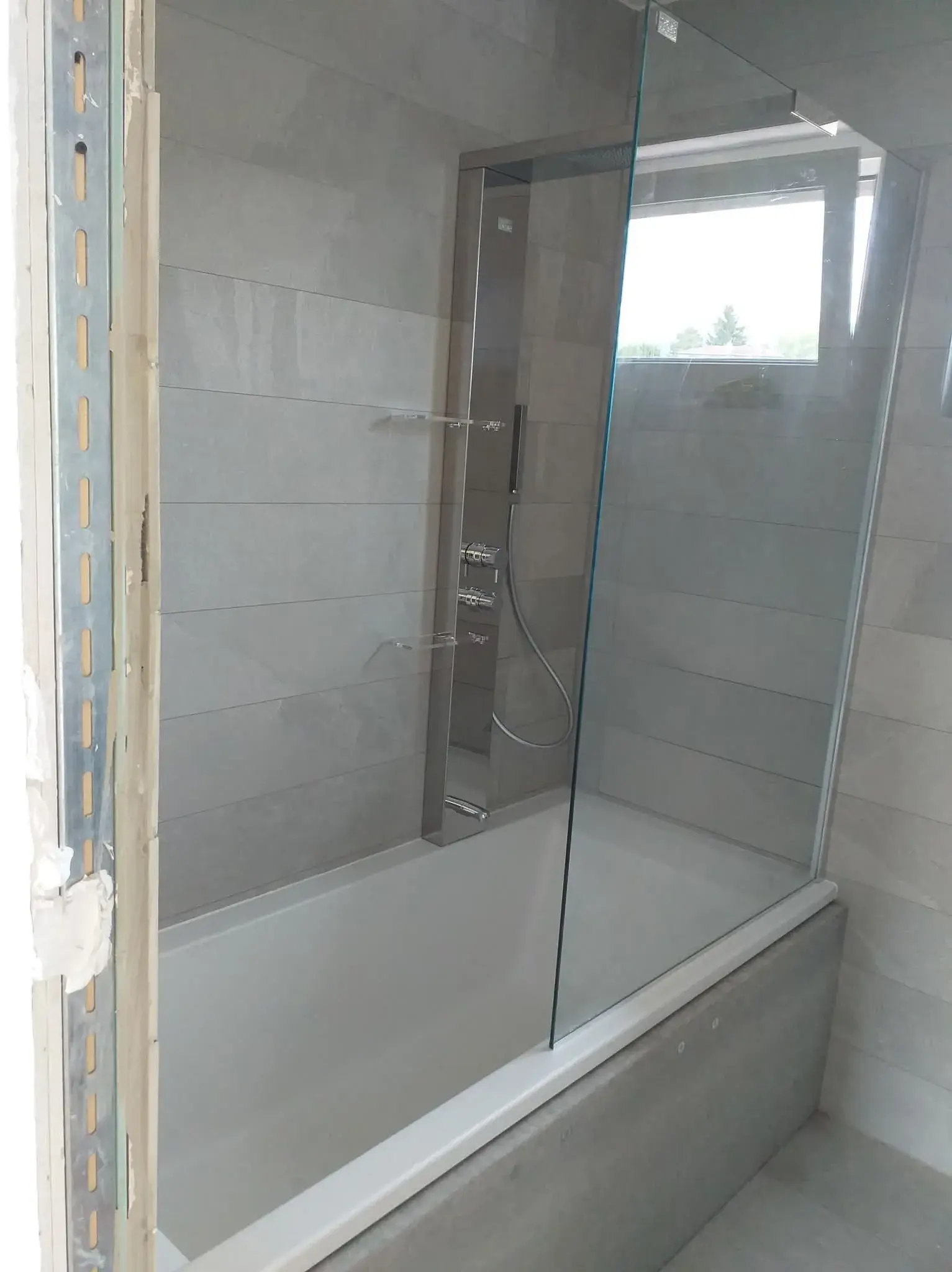 Colonne de douche chromée avec douche de pluie et douchette, salle de bain bleue.