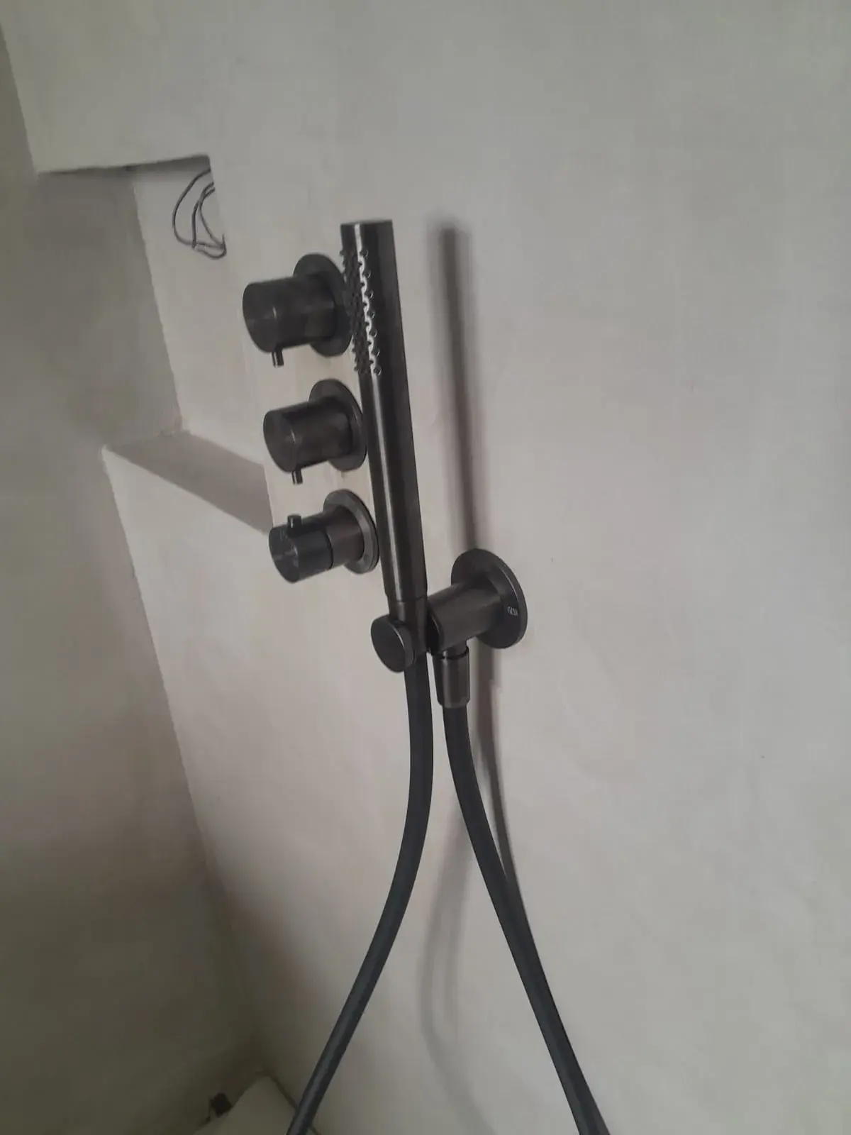 Détail de la robinetterie noire encastrée, salle de bain design.