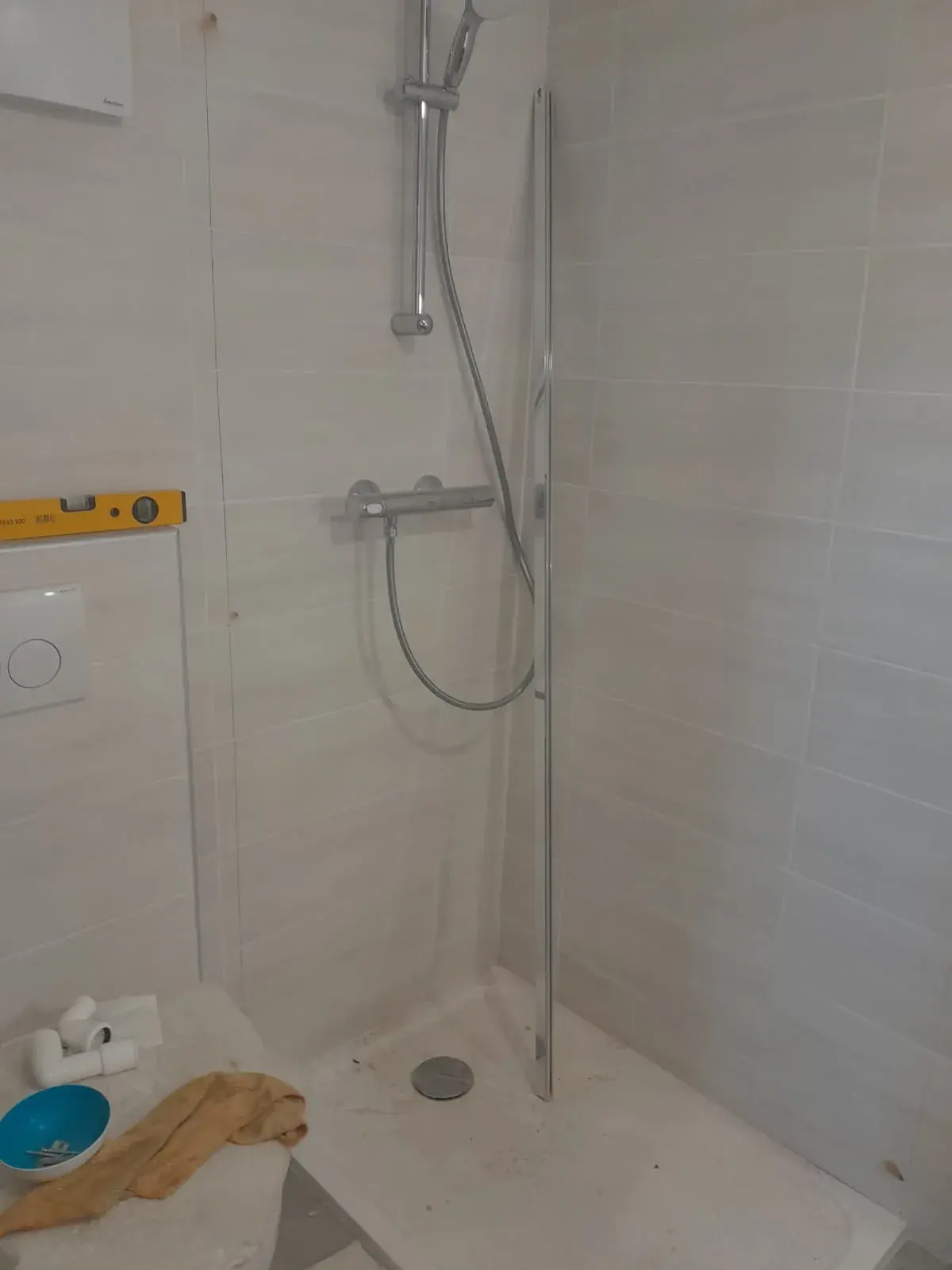 Robinetterie de douche chromée sur douchette coulissante, salle de bain en finition.
