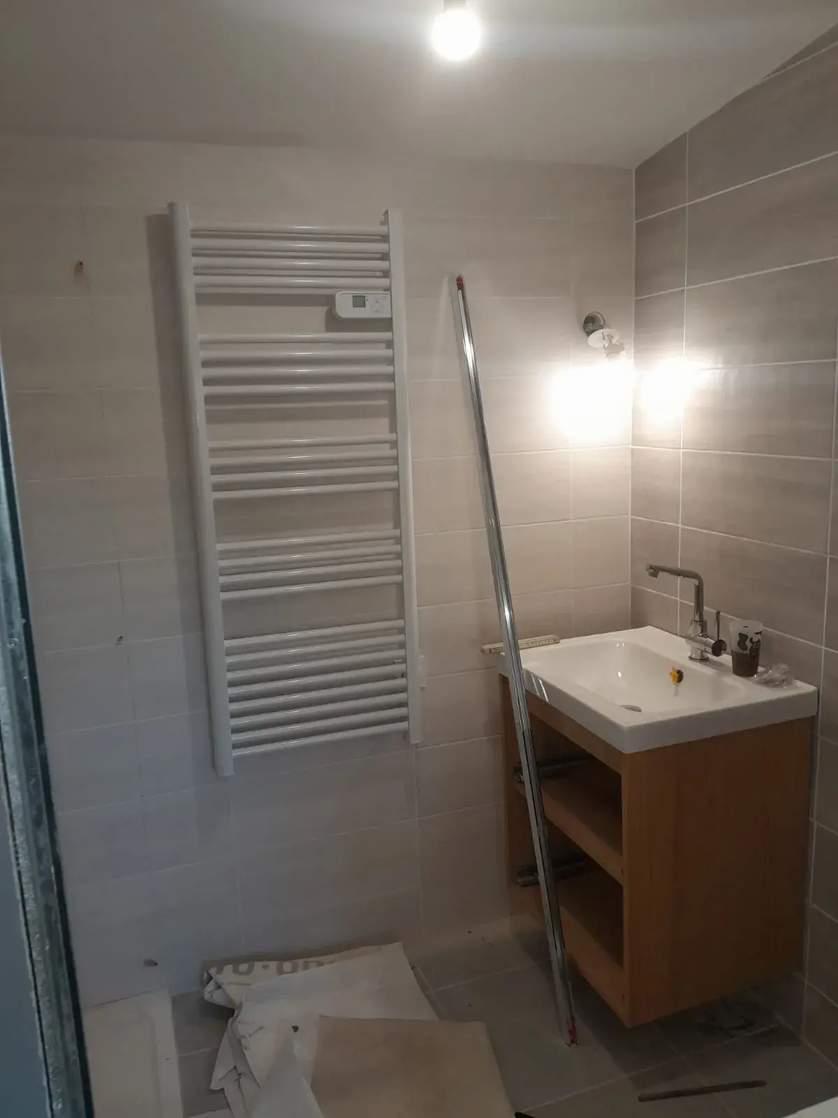 Vasque en chêne clair et sèche-serviettes électrique, salle de bain en finition.