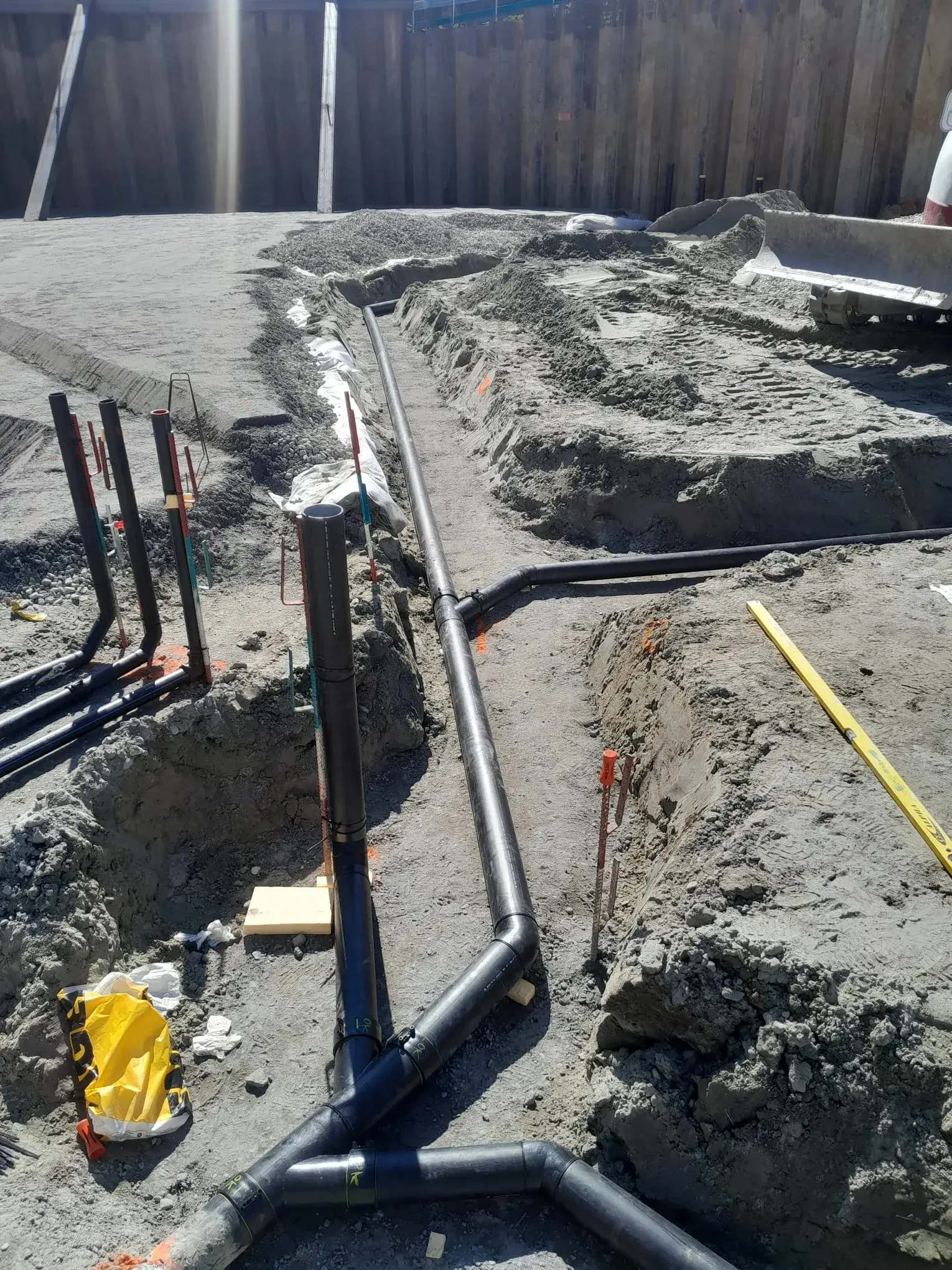 Vue large de la tranchée de réseaux enterrés avec plusieurs raccords.