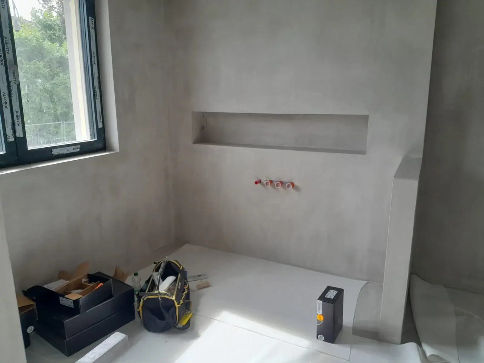 Vue large de la niche murale avec attentes de plomberie, avant finition.